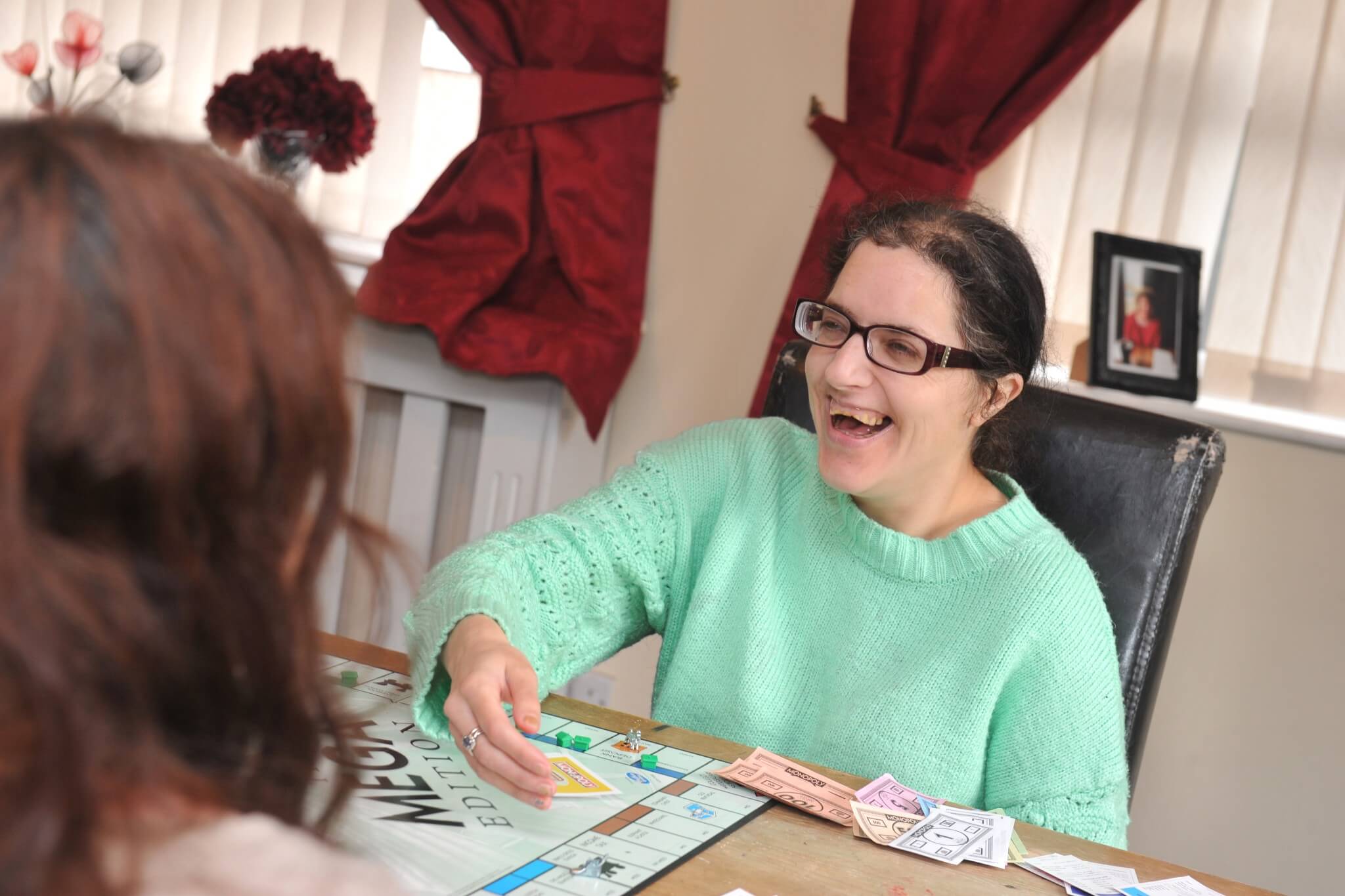 Lady in sea foam jumper playing a board game