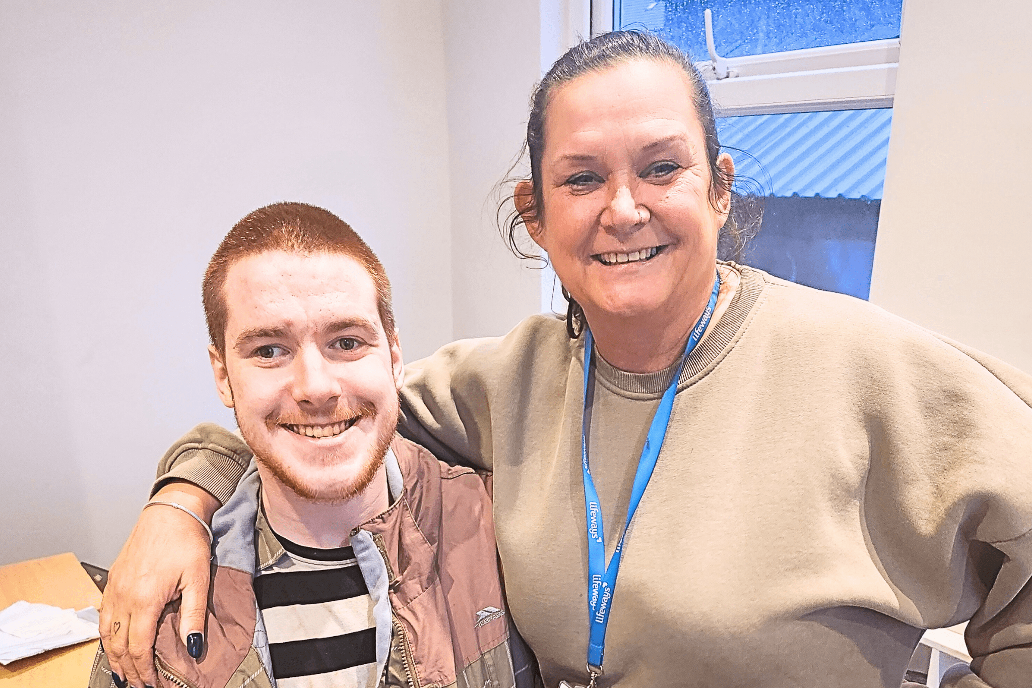 A young man and his support worker, happy and smiling