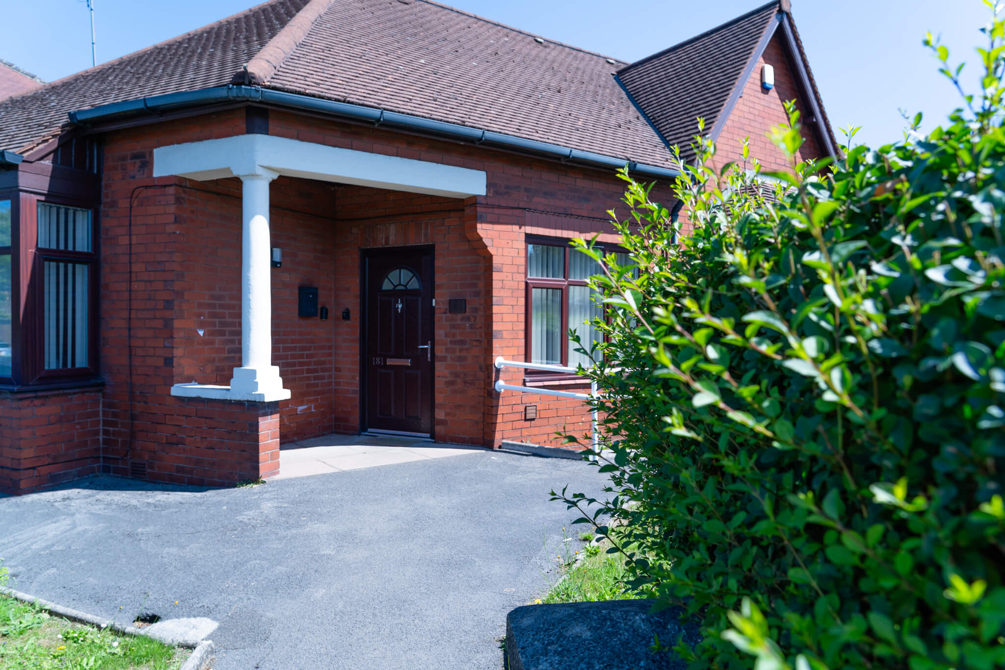 A driveway to a lovely looking home on a sunny day