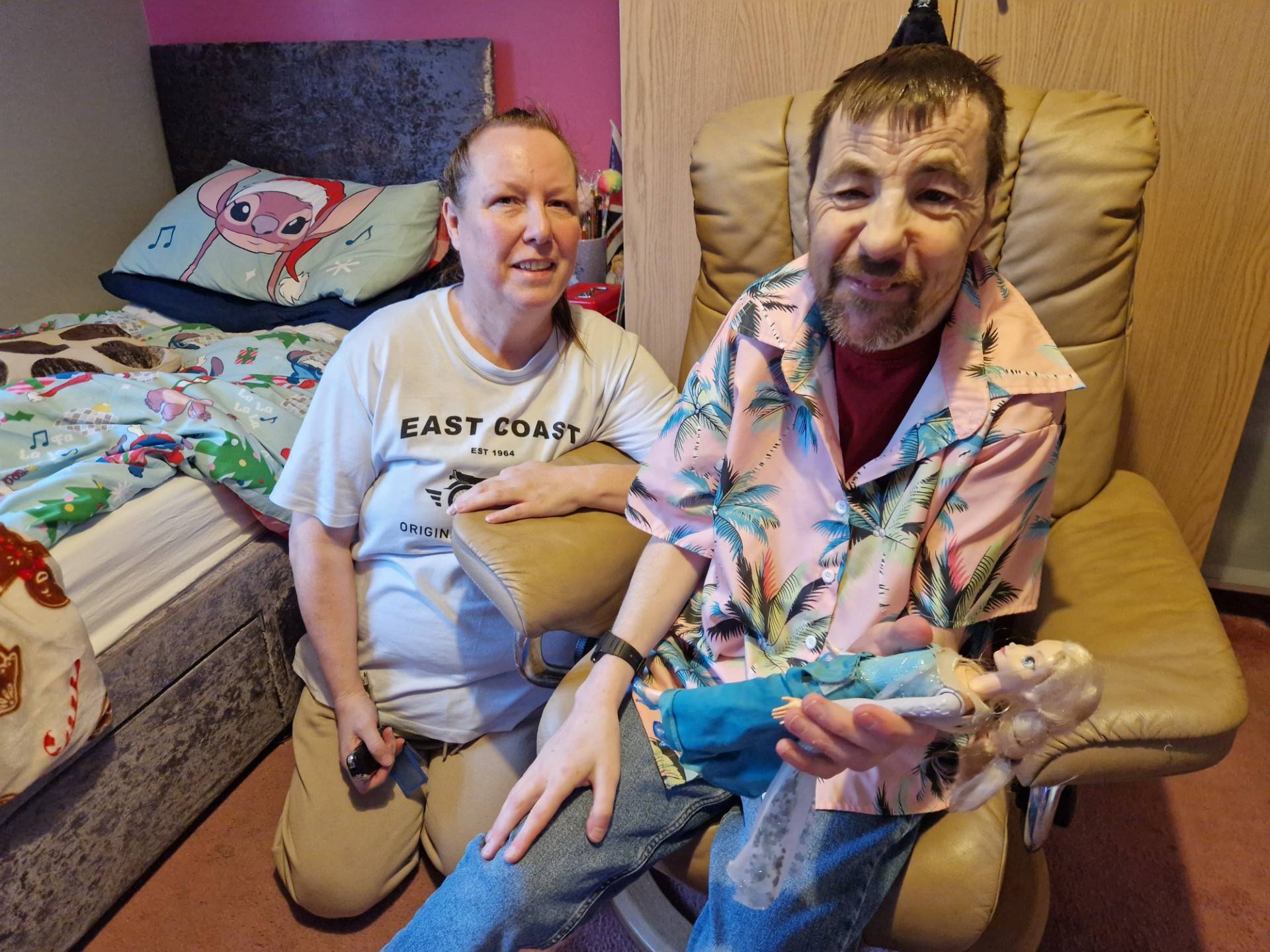 Two people sitting in a bedroom