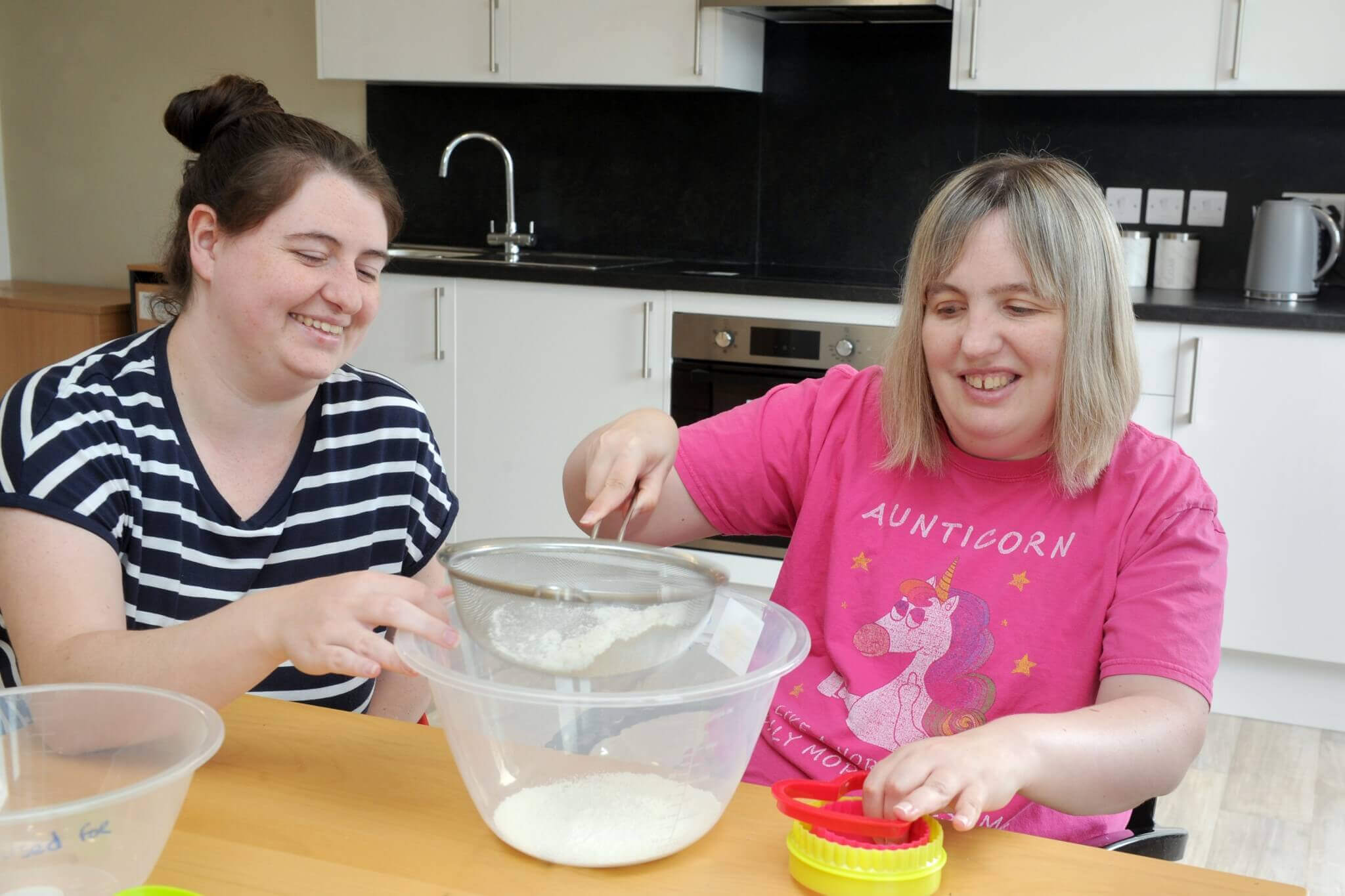 Lady sieving flour in the kitchen