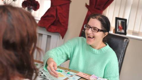 Lady in sea foam jumper playing a board game
