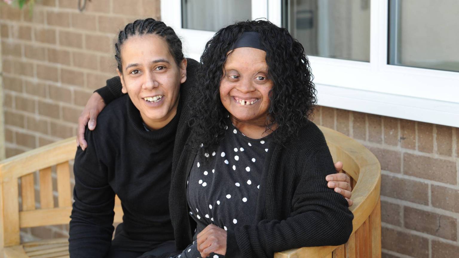 Lifeways team member and person we support sat together and smiling