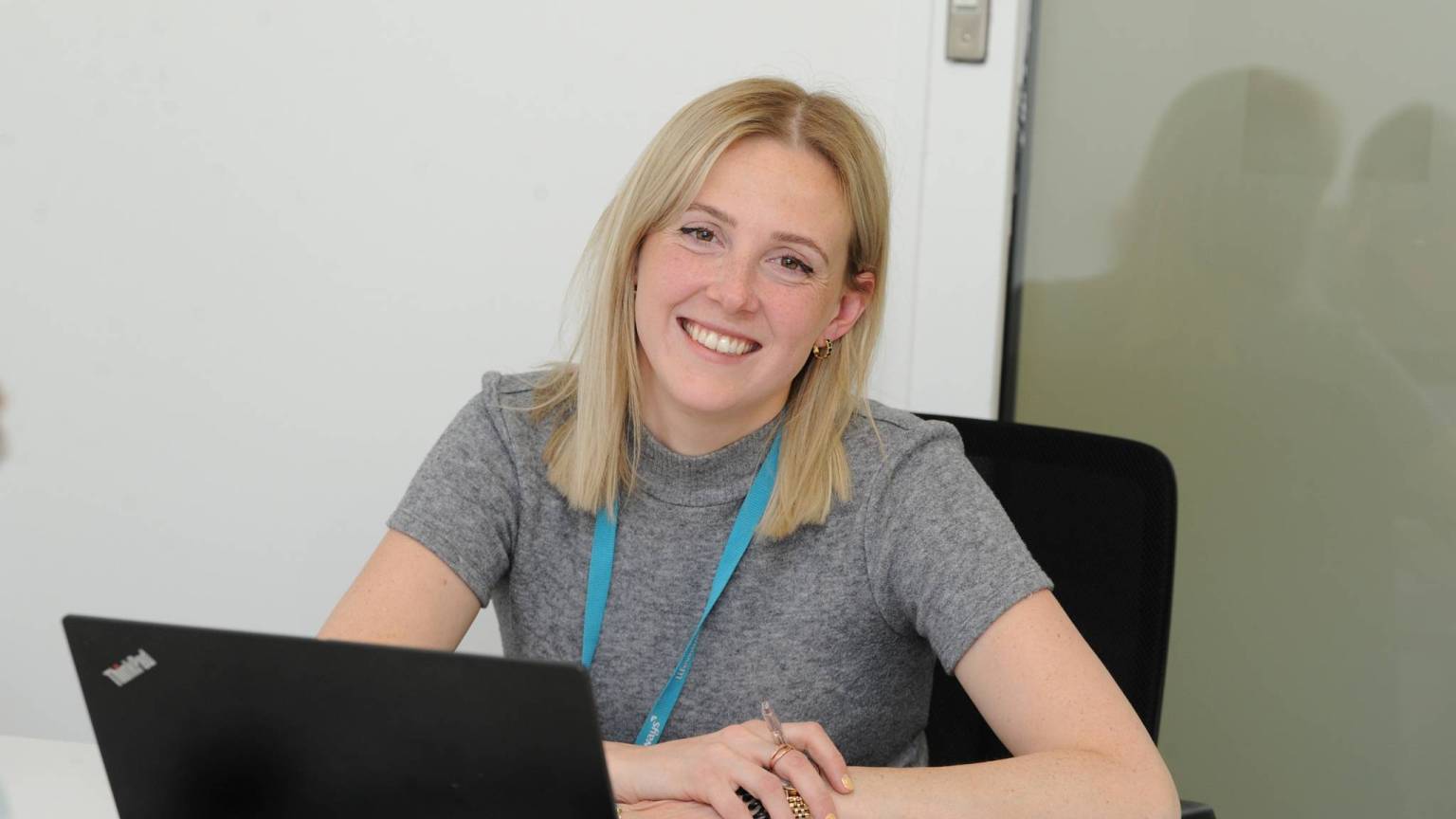 Lady with laptop smiling into camera