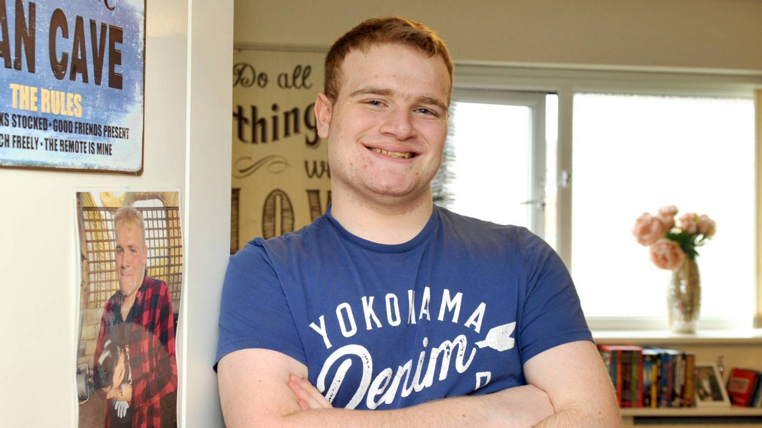 Person we support smiling while leaning against bedroom wall