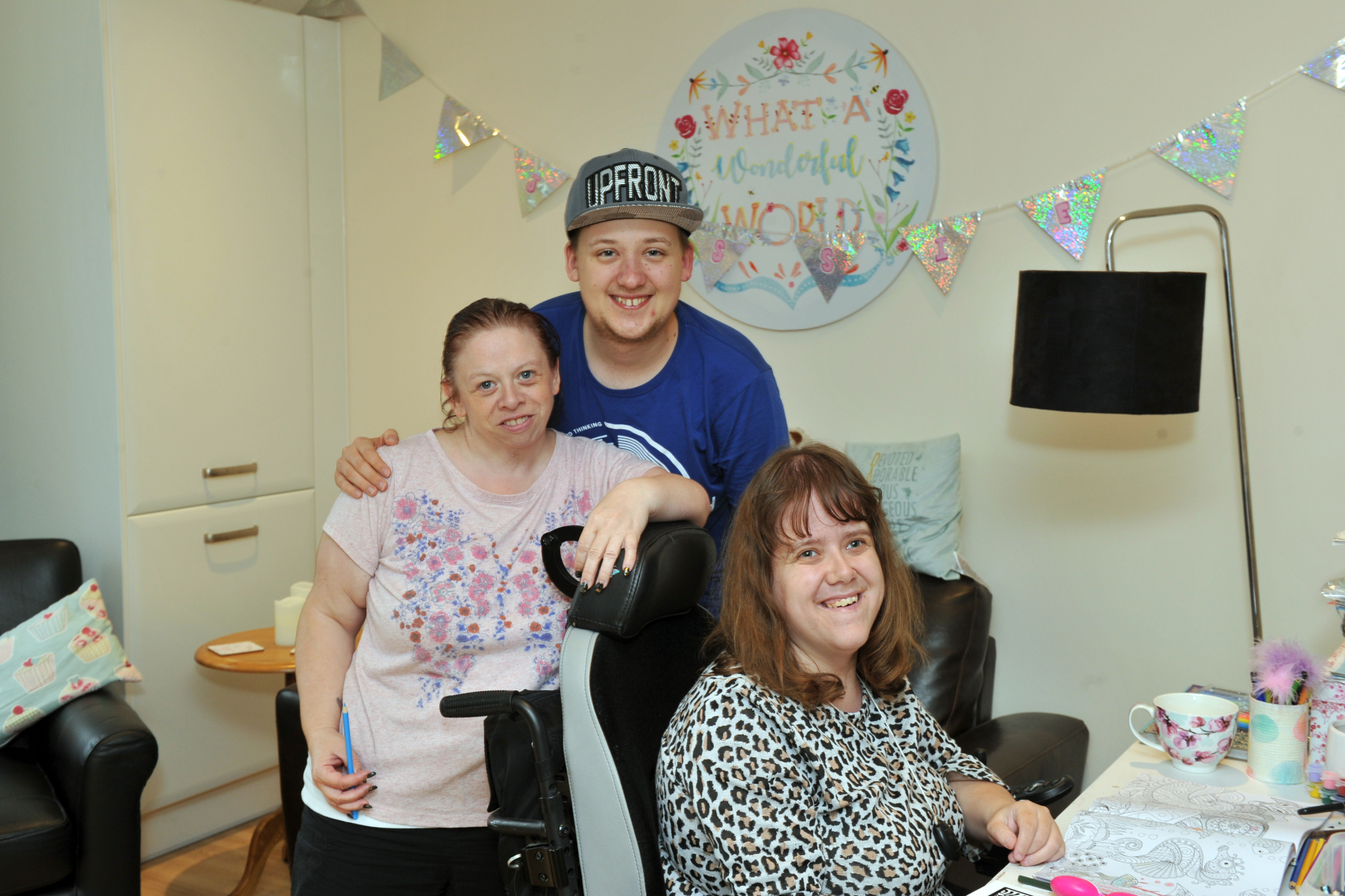residents in a shared house standing and sitting together, smiling for a photo