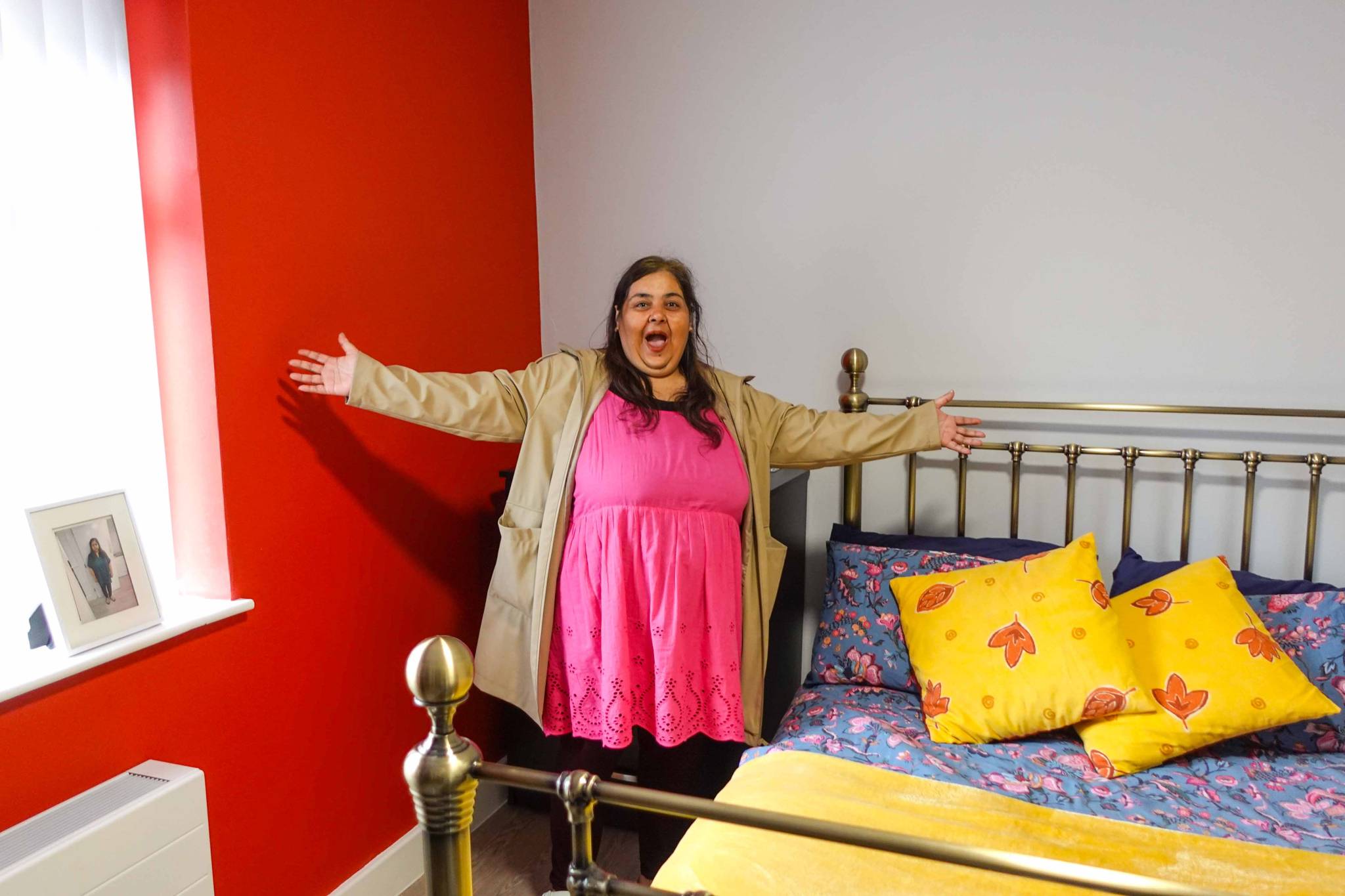A picture of a person we support showing off the new red colour scheme in her room