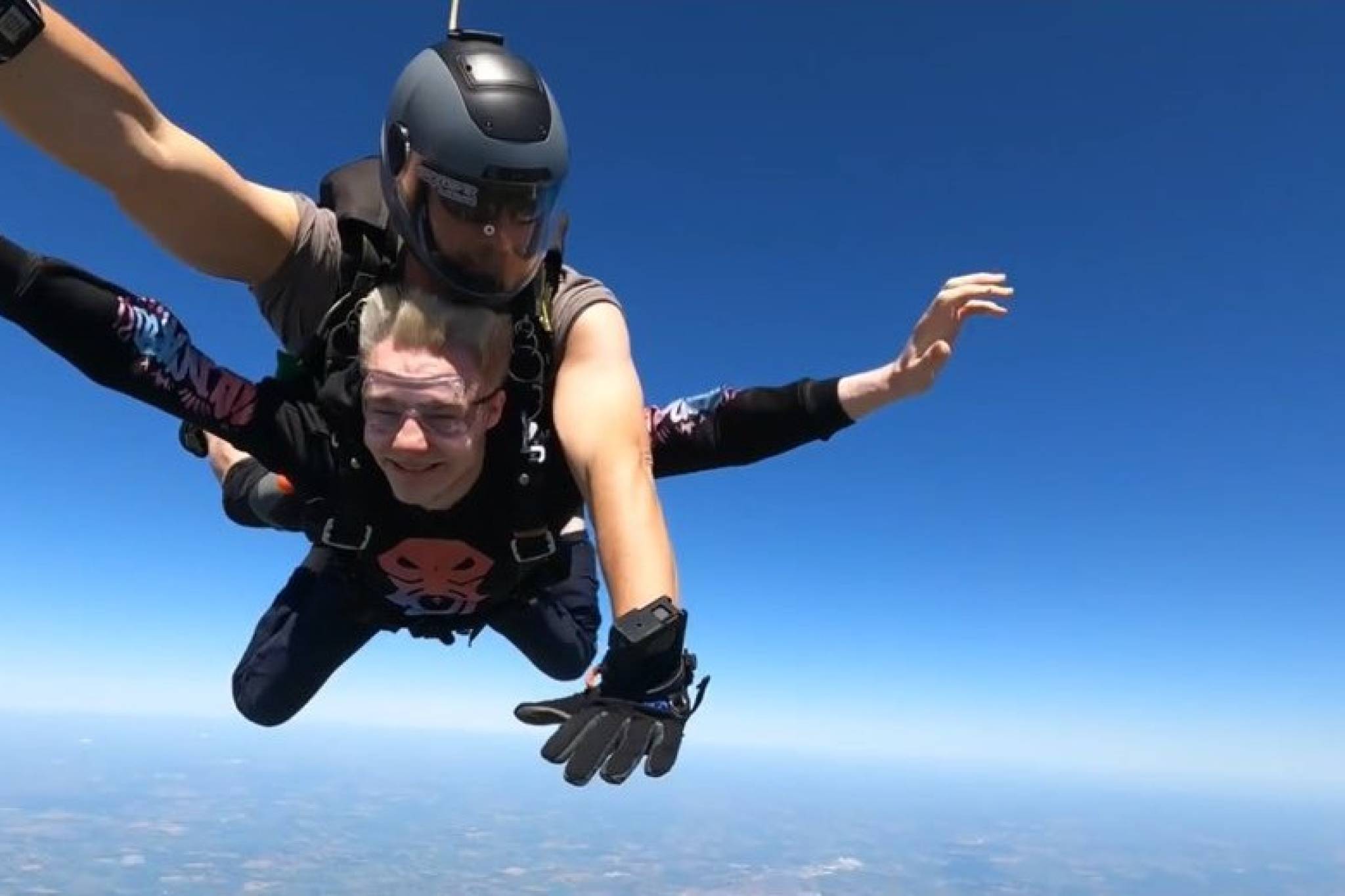 Makye flying through the air during his skydive with professional skydiver guiding him