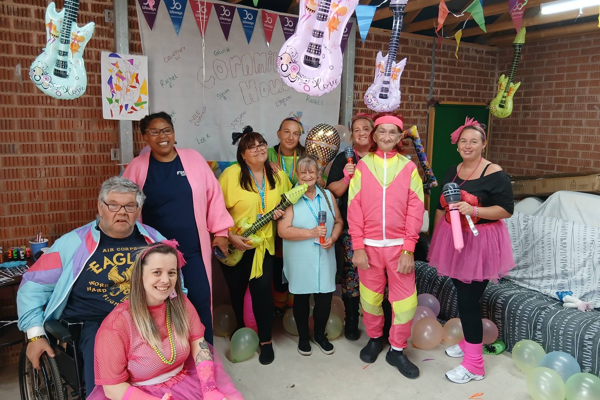 A group of staff and people in support celebrating a birthday party